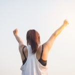 The Right Way to Prep for a Bikini Competition (Part 3) The Road to Recovery woman with arms stretched out in achievement